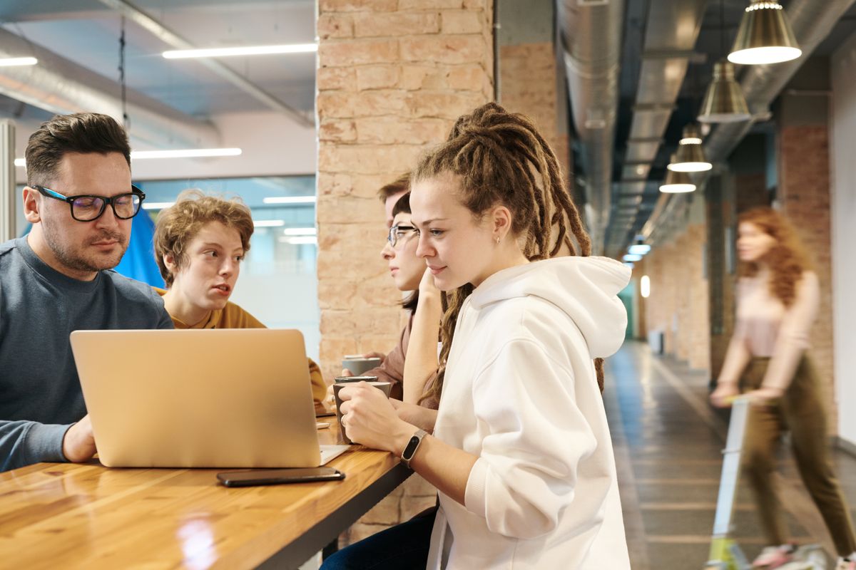 A small, senior team working together at a laptop.